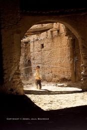 Image du Maroc Professionnelle de  Un petit garçon joue dans une rue à Ksar Boudnib, la cité est  située dans le Tafilalet à 90 km d’Erfoud et au Sud-est à environ 100 km d’Errachidia. La région dispose d'innombrable potentialité touristique, Dimanche 15 Avril 2007. (Photo / Abdeljalil Bounhar)
